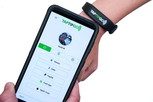 Person holding a phone with a 'Taptipgo' app and wearing a Taptipgo bracelet.